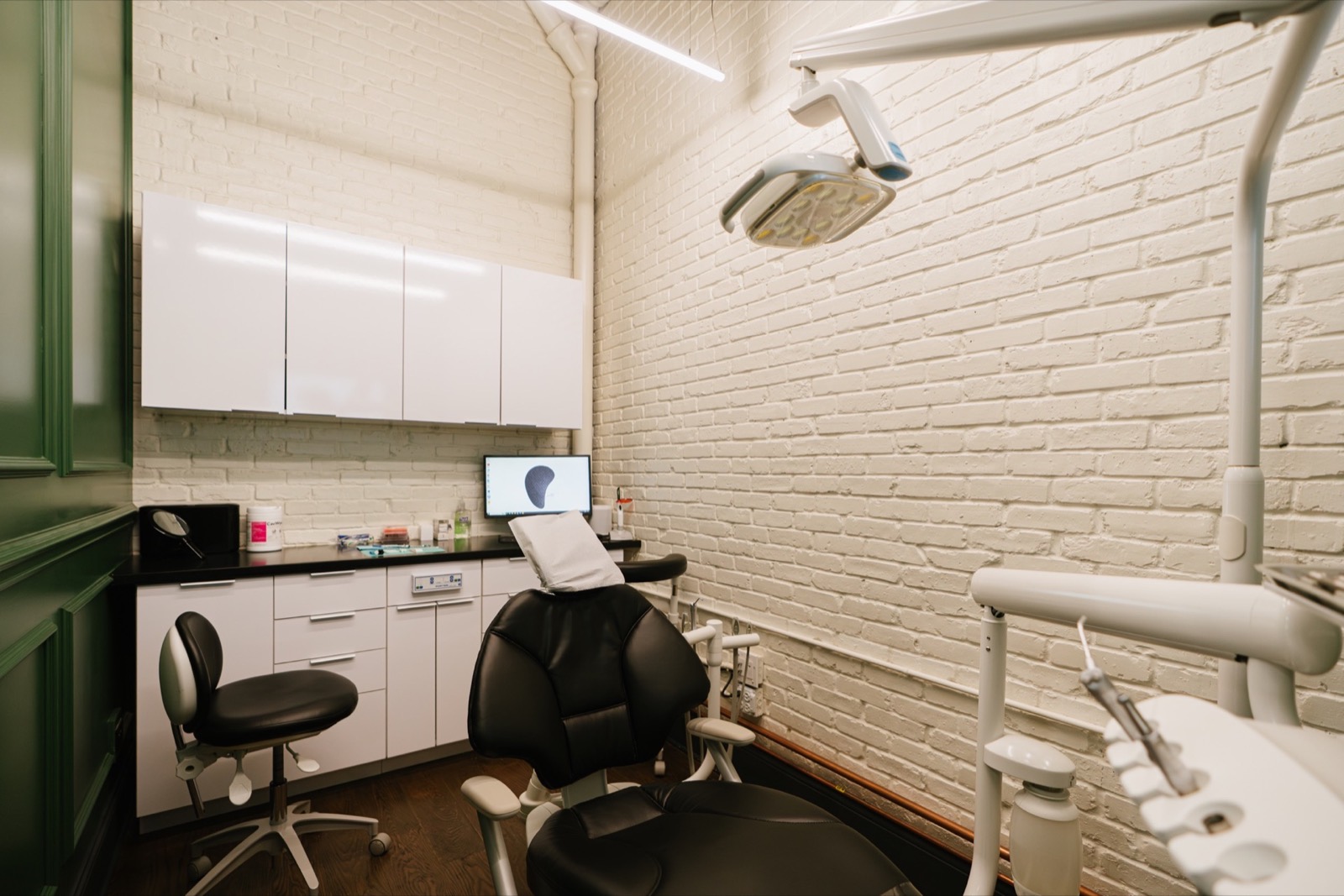 A treatment room at Pearl, white brick and green paneling
