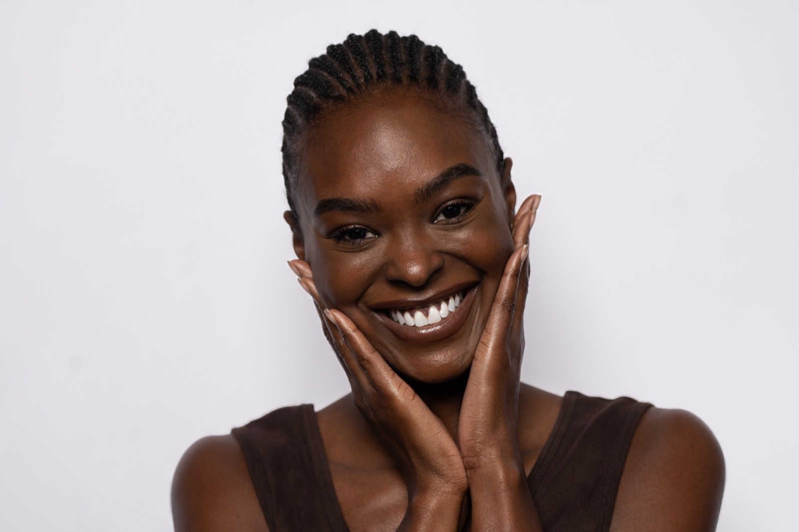 A woman smiling, her hands on her cheeks